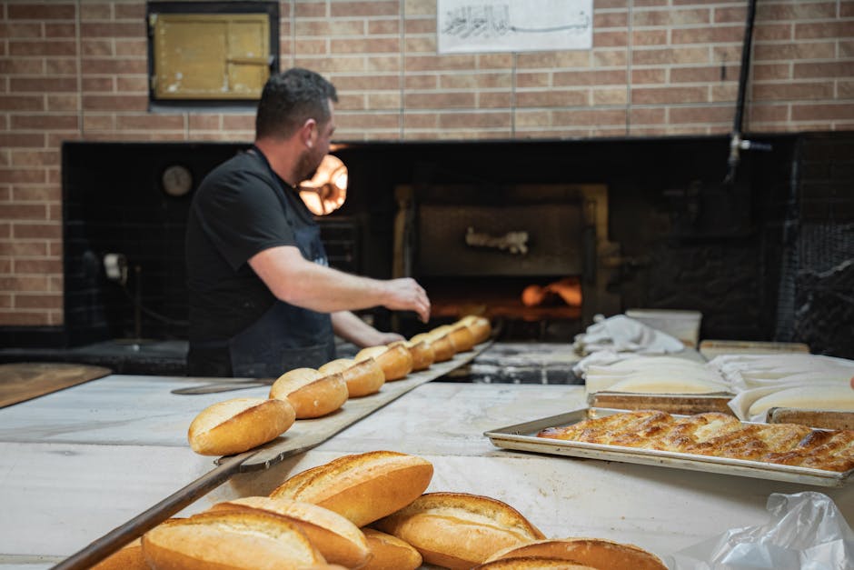 Baker preparing fresh bread in a brick oven bakery shop, highlighting artisanal craftsmanship and traditional methods.