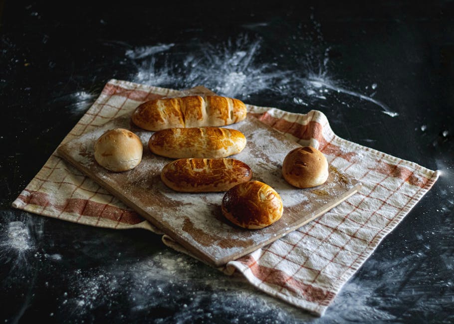 Artisanal bread styled with dark moody lighting on a flour-dusted board.